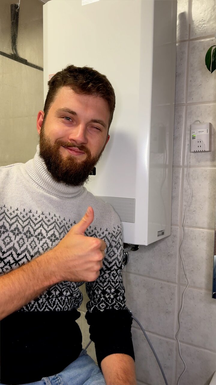 Axel steht zufrieden vor seine Gastherme und hält den Daumen hoch, alles ist jetzt sicher